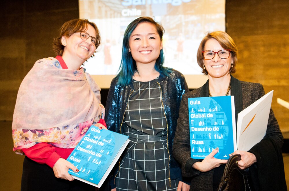 Three women holding the Portuguese translated Global Streets Design Guide